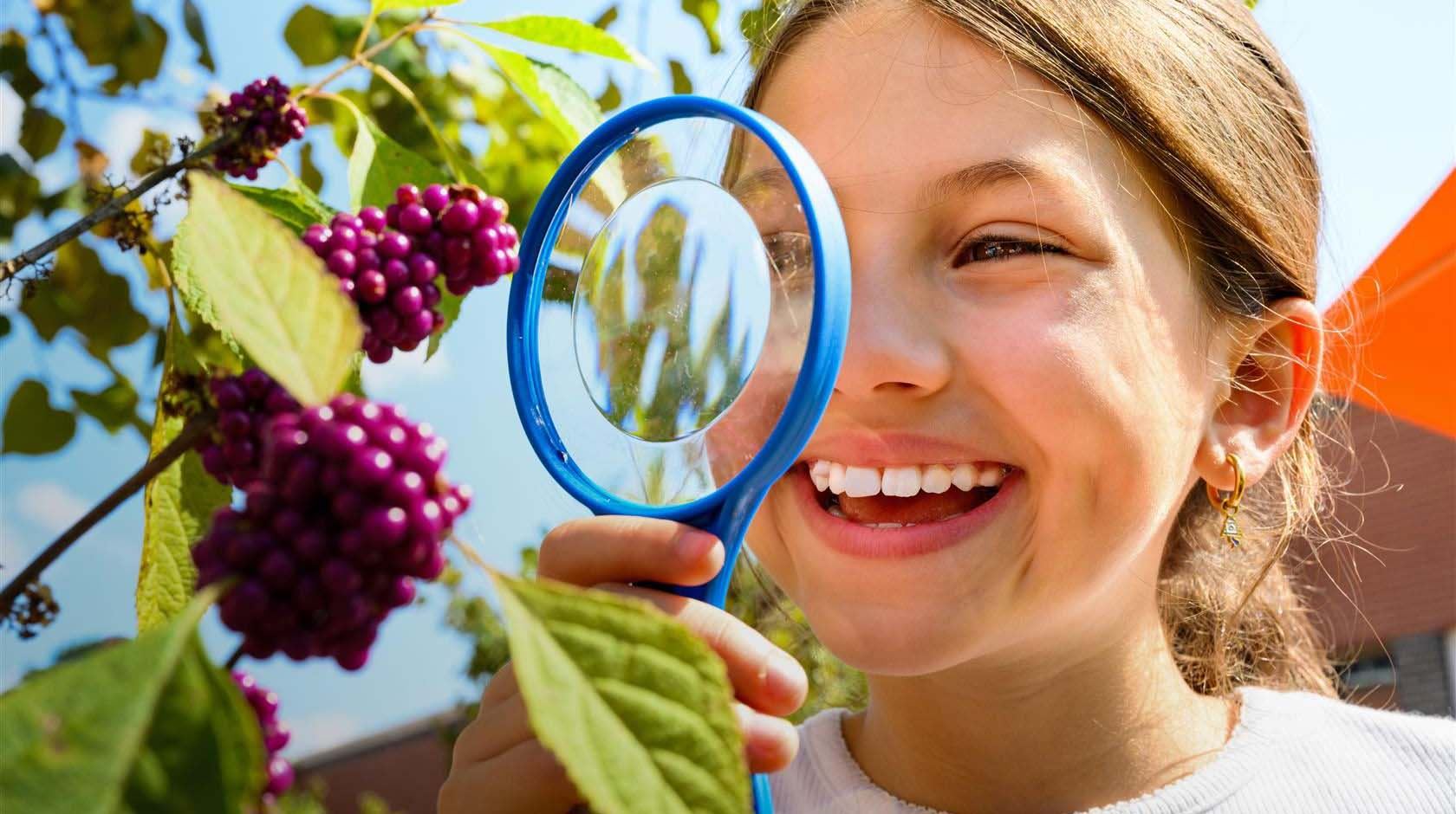  Student looking through a magnifying glass.
